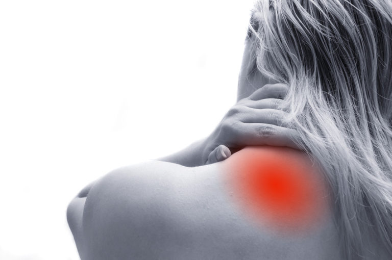 A woman against a stark white background presenting with shoulder / upper neck pain, depicted with a glowing red orb representing the pain.