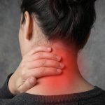 A woman, seen from behind, presenting with some upper back pain, the pain is visualised with a glowing red graphic overlaid.