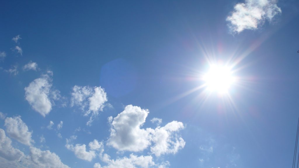 An image of a blue sky with sunlit clouds, depicting a feeling of contentment.