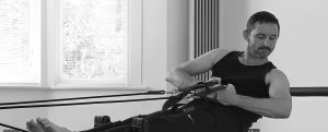 A photo of Luke Askew on the Reformer in The Pilates Studio